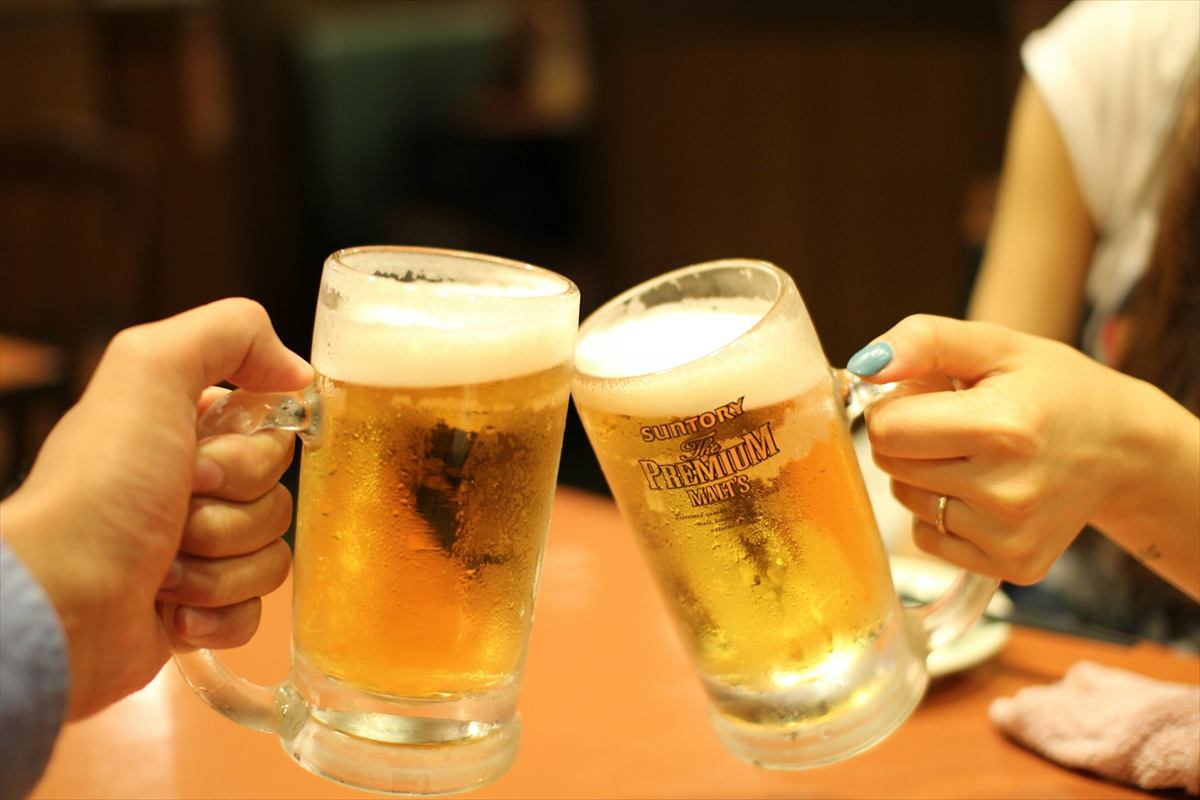 Duas canecas de chope gelado brindando sobre o balcão