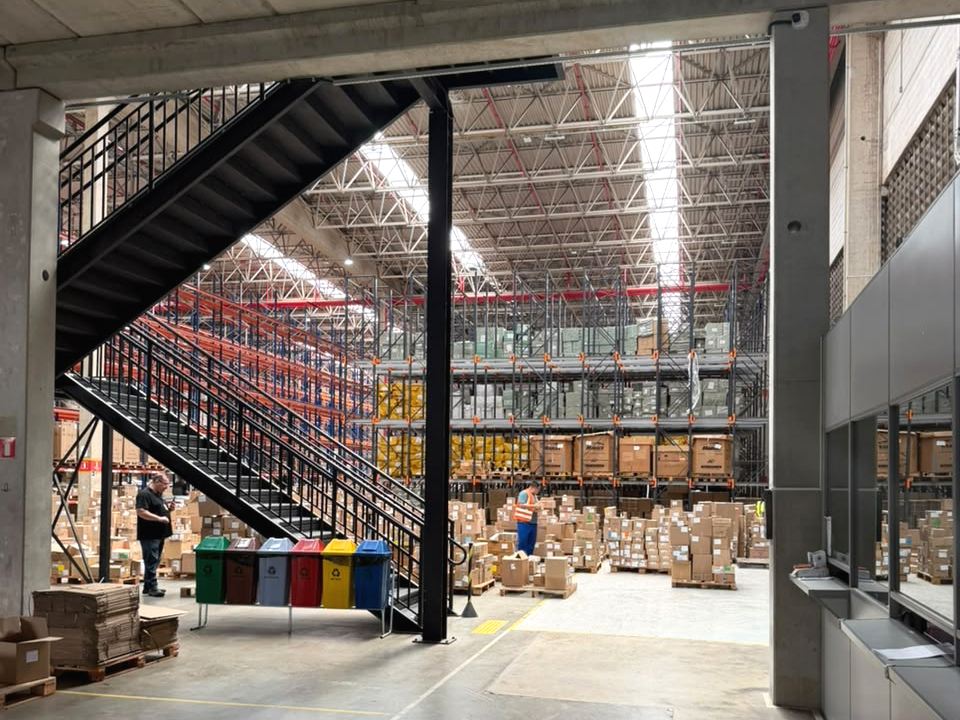 Centro de distribuição com estoque e escada de acesso ao mezanino